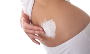 Woman applying cream on her stomach to illustrate what about weight loss surgery scars